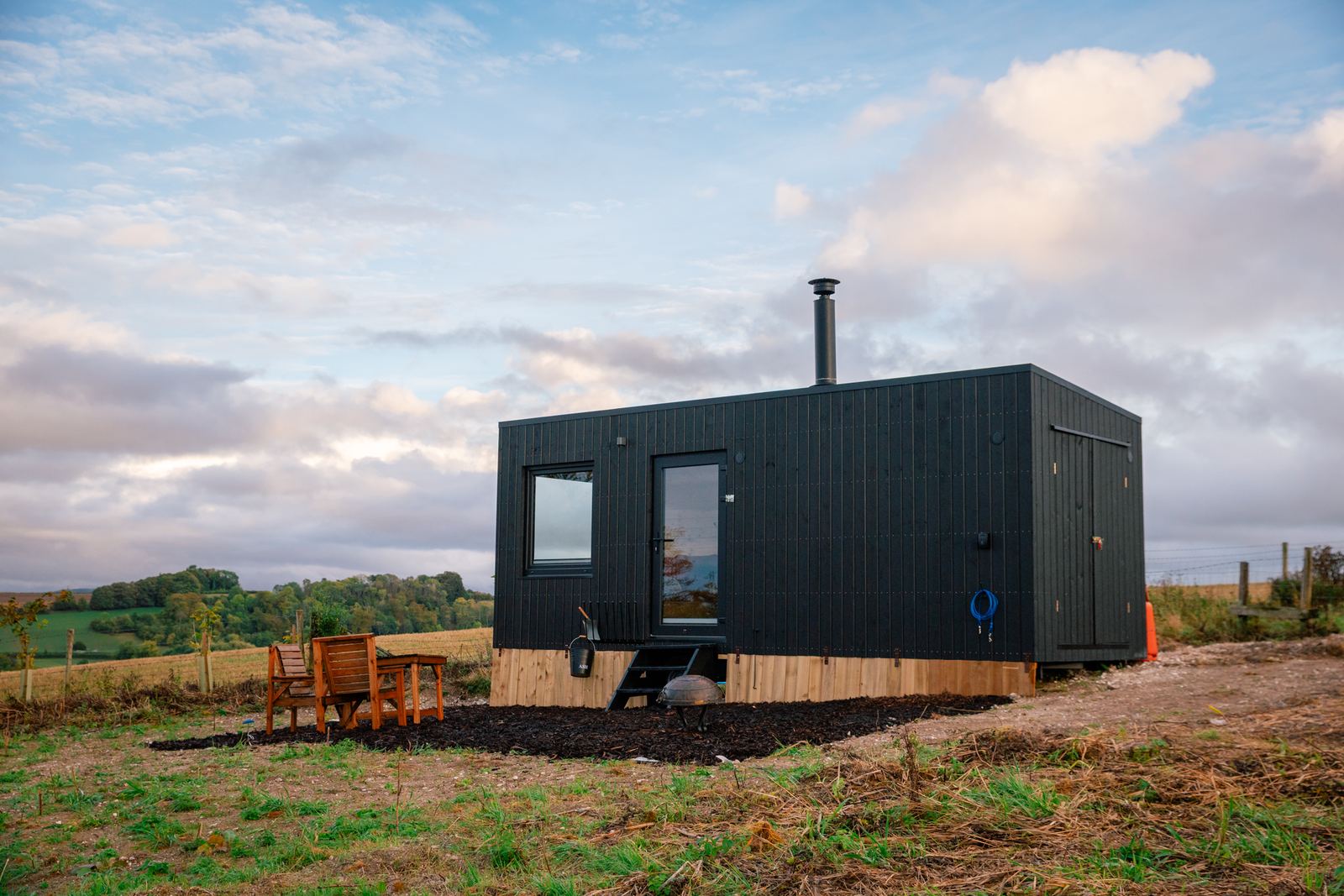 Bedroom in a HIDE n SEEK off-grid cabin looking out over the countryside